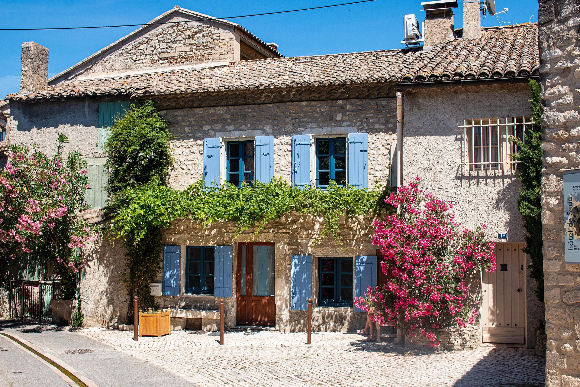 Maison en pierre avec volets bleus et bougainvilliers en Provence – chambre d’hôtes typique